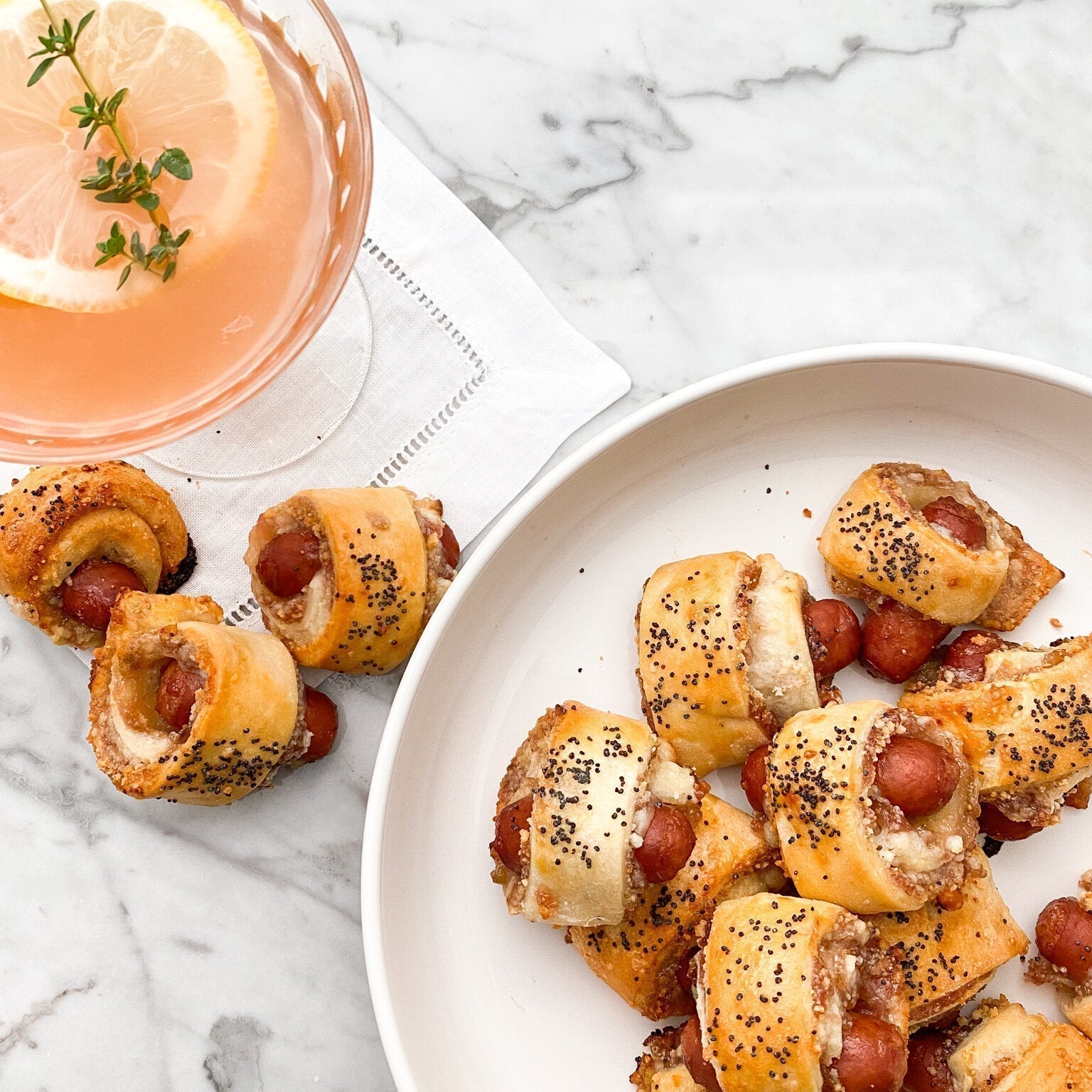 Golden brown Figgy Piggies in a Blanket appetizers with fig jam and parmesan cheese on a serving platter