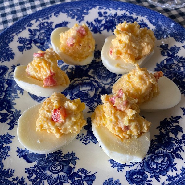 Pimento cheese deviled eggs arranged on white platter Southern appetizer recipe