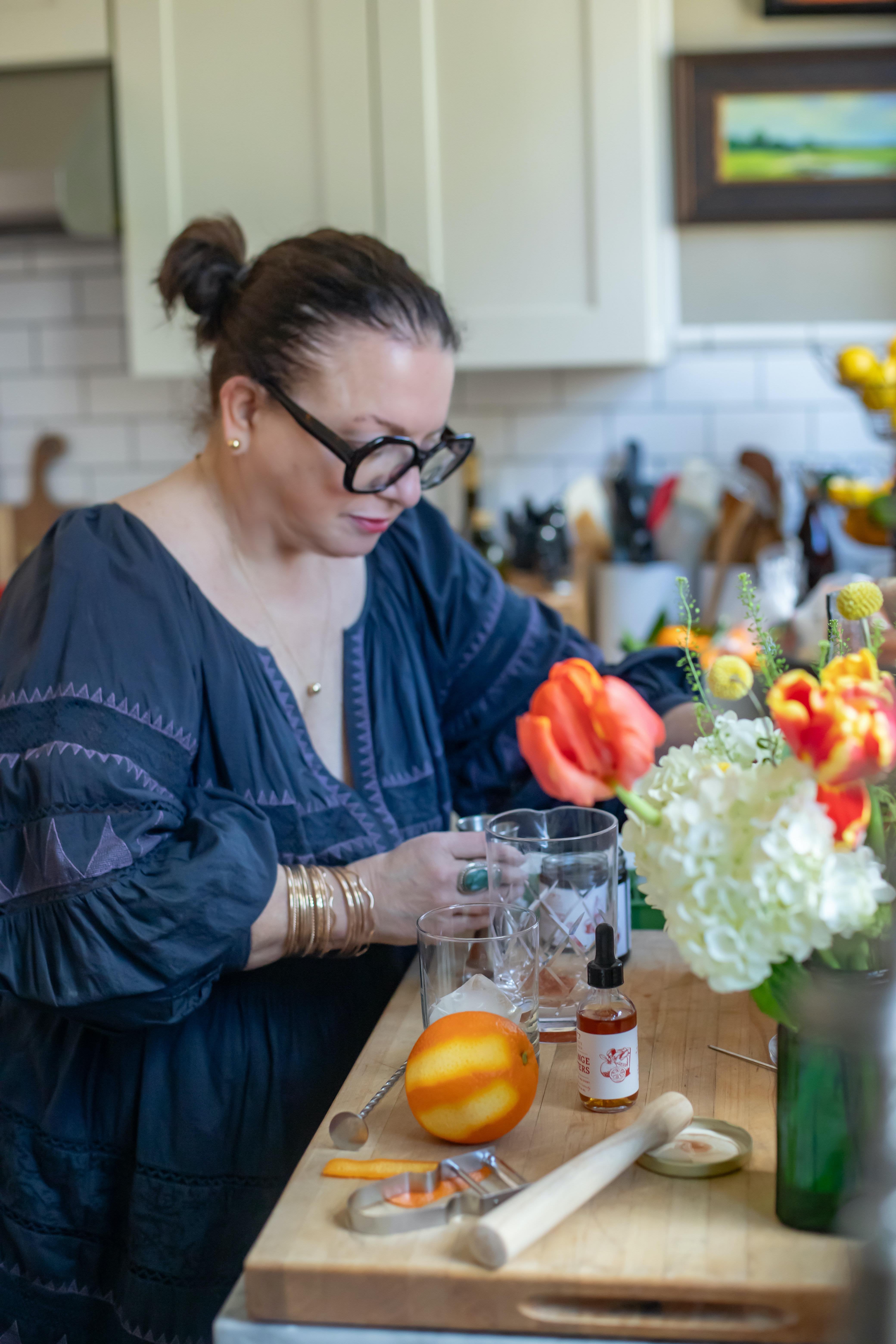 Warm winter dinner party table setting with vintage brass candlesticks, brown transferware dishes, and brown gingham tablecloth creating a cozy, earthy atmosphere