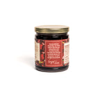 Jar of cherry preserves with a red label on a white background