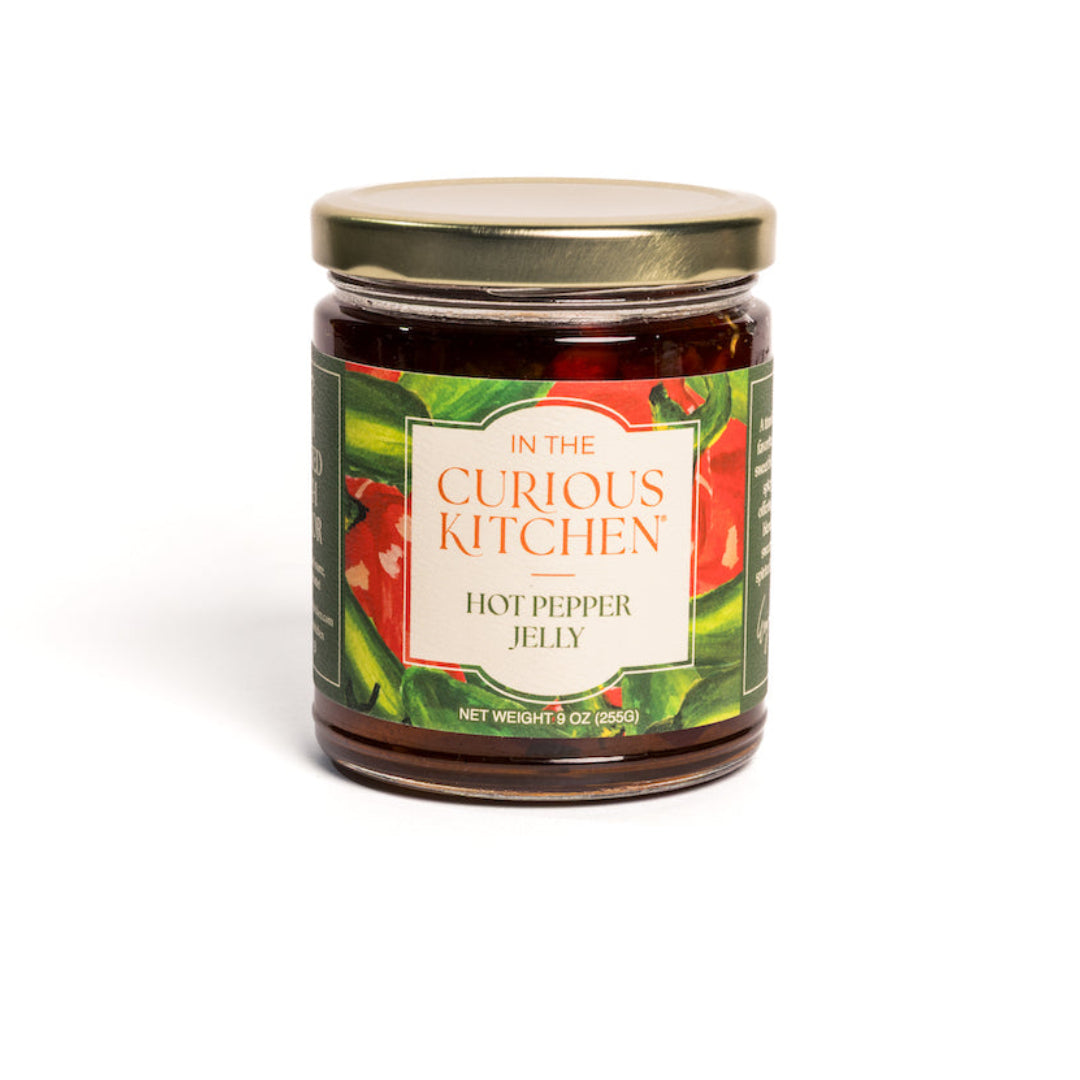 Jar of hot pepper jelly from 'In the Curious Kitchen' on a white background