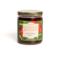 Jar of hot pepper jelly from 'In the Curious Kitchen' on a white background