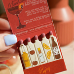 Pack of mini bottles with cocktail illustrations and text on a red background