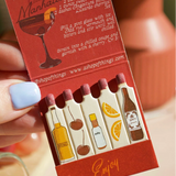 Pack of mini bottles with cocktail illustrations and text on a red background